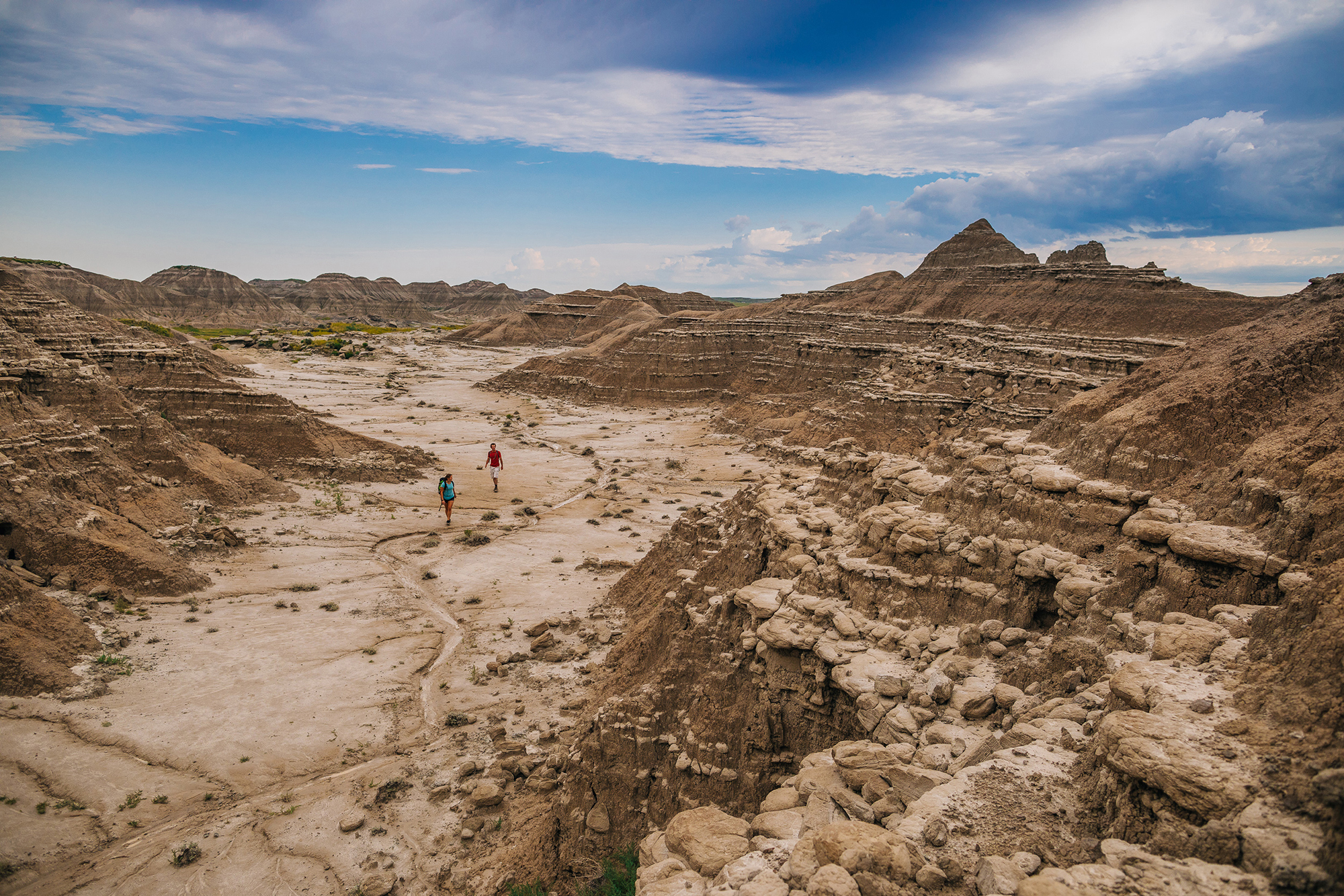 Two people walking through the Badlands of Toadstool Geologic Park.