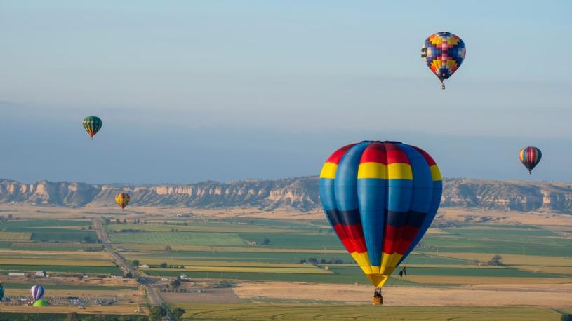 Hot air balloons with Scotts Bluff National Monument in the background at Old West Balloon Fest.