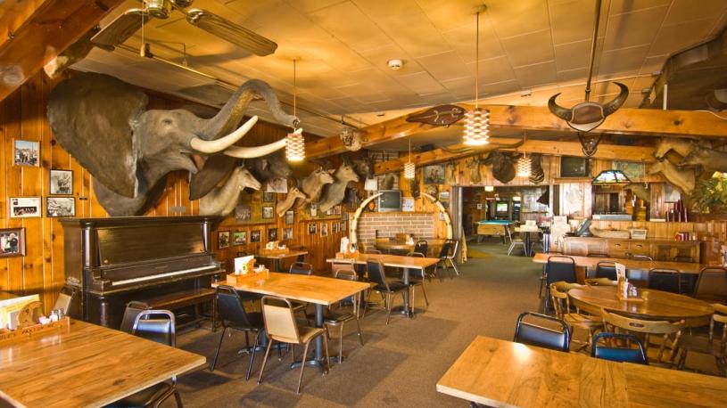 Table surrounded by big game trophies at Ole's Big Game Steakhouse in Paxton.