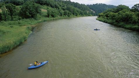 Two kayakers explore the lush banks of the Niobrara National Scenic River in Nebraska.