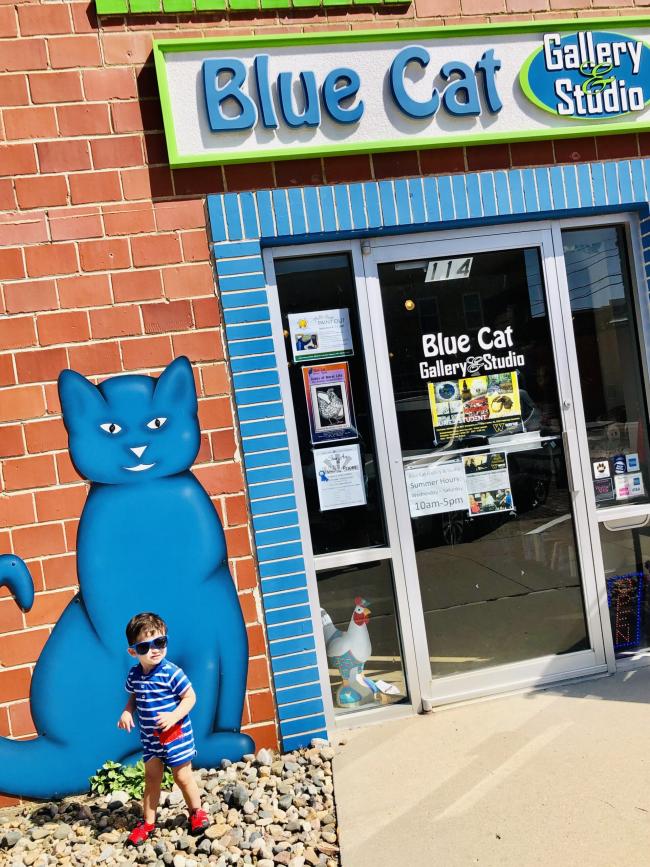 Little boy in front of blue cat