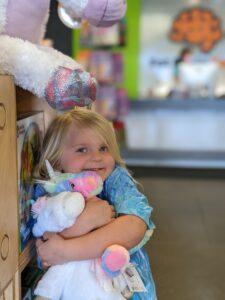 Girl hugging stuffed unicorn